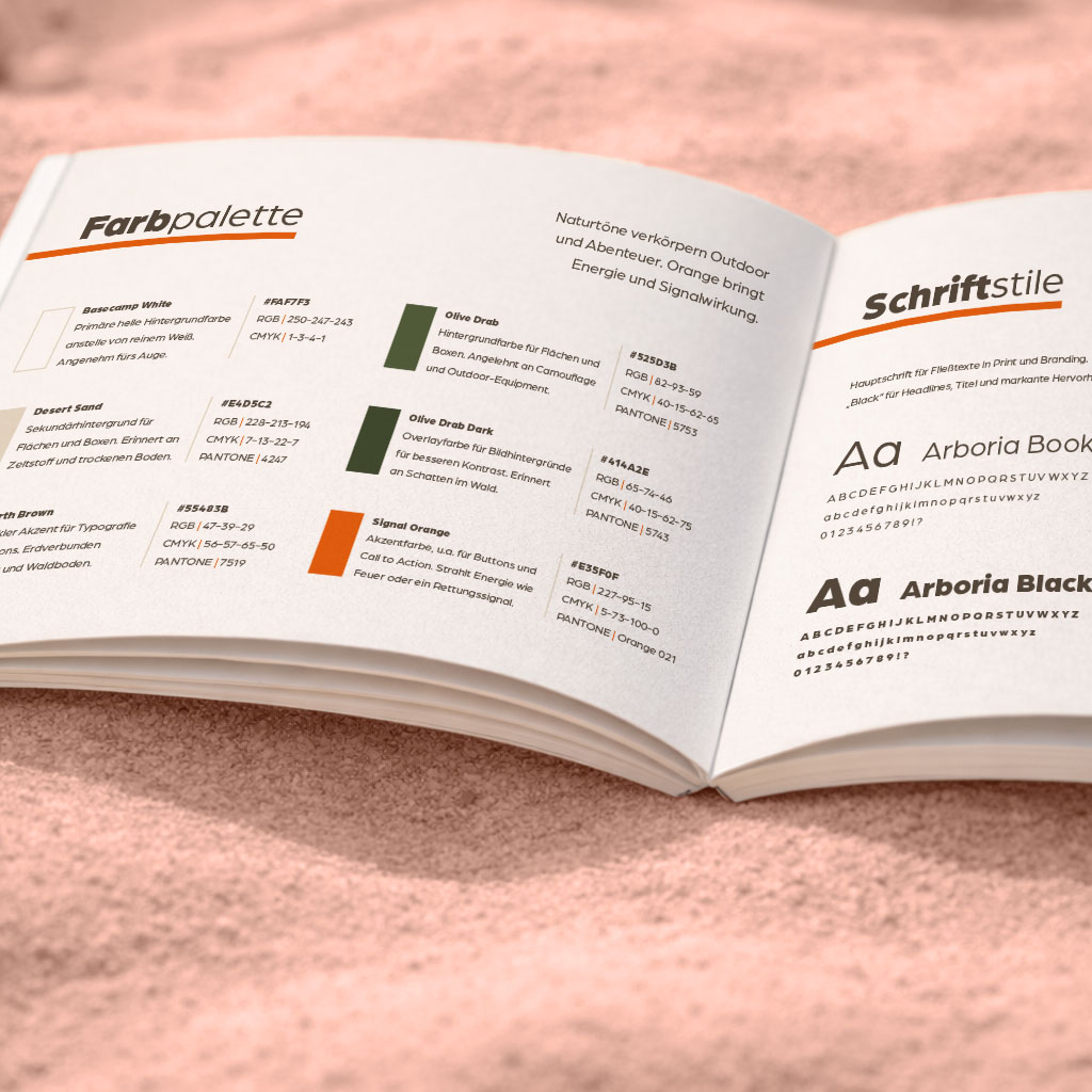 Brand Styleguide MRE's & more aufgeschlagen auf Sand mit Kompass und Fernglas, zeigt Seiten mit Farbpalette und Typografie